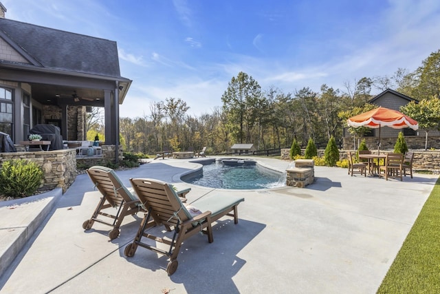 outdoor pool featuring ceiling fan, a patio, a bar, and fence