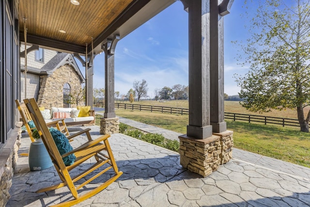 view of patio featuring fence and a rural view