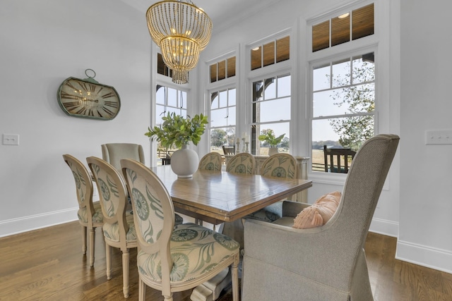 dining room featuring a healthy amount of sunlight, a chandelier, and dark wood finished floors