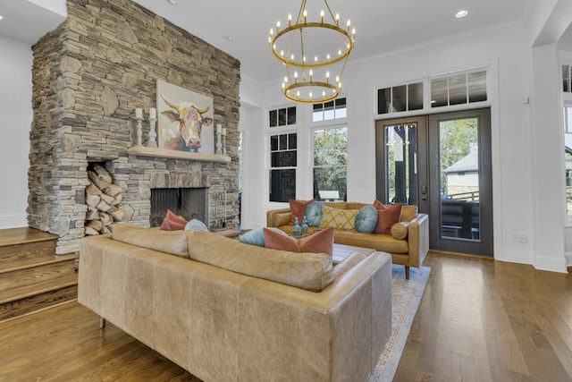 living area featuring a fireplace, wood finished floors, and crown molding