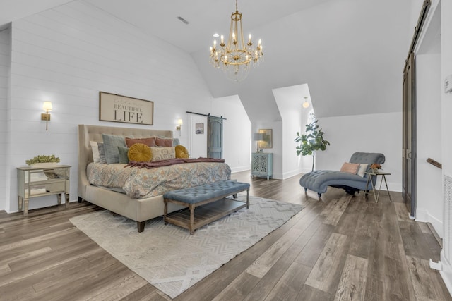 bedroom featuring high vaulted ceiling, wood finished floors, visible vents, and a barn door