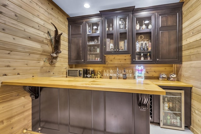 bar featuring a dry bar, beverage cooler, and wooden walls