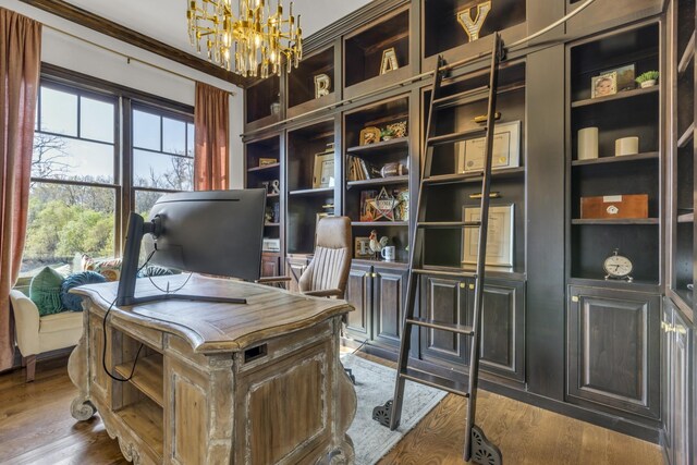 home office with dark wood-type flooring and an inviting chandelier