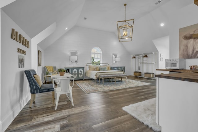 bedroom featuring lofted ceiling, dark wood-style floors, visible vents, and a notable chandelier