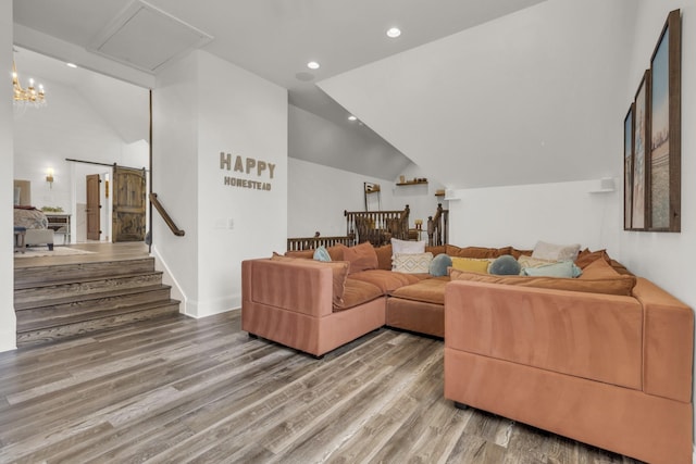 living room featuring lofted ceiling, a barn door, recessed lighting, wood finished floors, and stairway