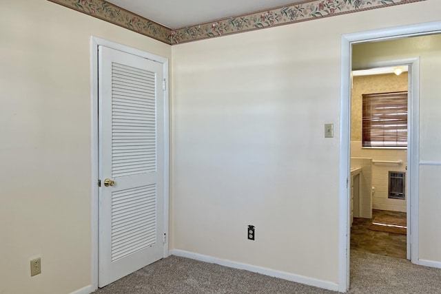 unfurnished bedroom with carpet, baseboards, and a closet