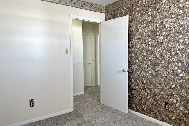 unfurnished room with carpet floors and baseboards