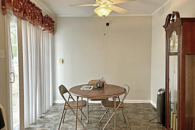 dining area featuring baseboards, ceiling fan, stone finish floor, and crown molding