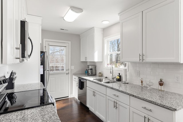 kitchen featuring light stone countertops, appliances with stainless steel finishes, and white cabinets