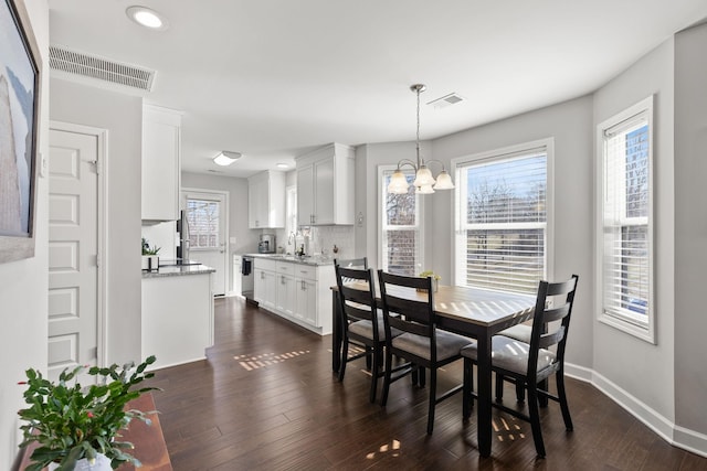 dining room with a wealth of natural light, visible vents, and dark wood-type flooring