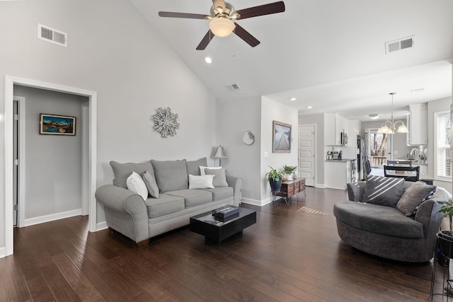 living area featuring high vaulted ceiling, visible vents, dark wood finished floors, and baseboards