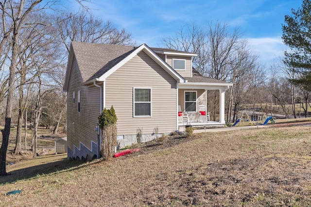 bungalow-style home with roof with shingles, a playground, covered porch, crawl space, and a front lawn