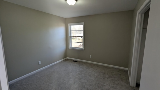 carpeted empty room featuring visible vents and baseboards