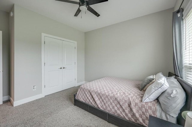 bedroom with a ceiling fan, carpet, a closet, and baseboards