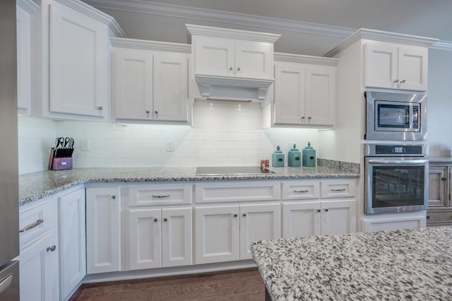 kitchen featuring crown molding, stainless steel appliances, white cabinets, light stone countertops, and extractor fan