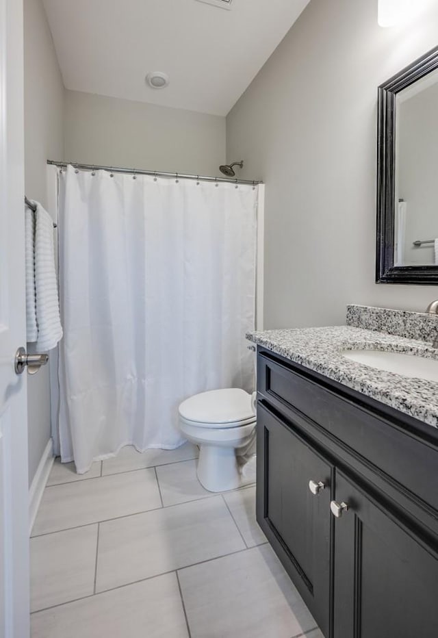 bathroom featuring toilet, vanity, and a shower with curtain