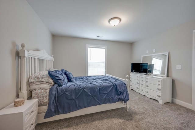 bedroom featuring baseboards, visible vents, and light colored carpet