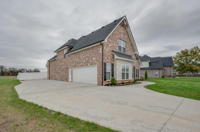 view of home's exterior with a standing seam roof, brick siding, driveway, and a lawn