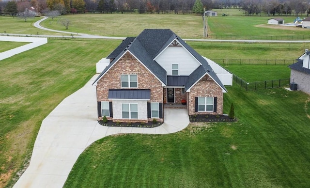 view of front of property with metal roof, brick siding, fence, a front lawn, and a standing seam roof