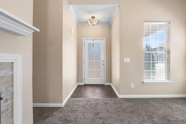 entrance foyer with a healthy amount of sunlight, carpet, baseboards, and crown molding