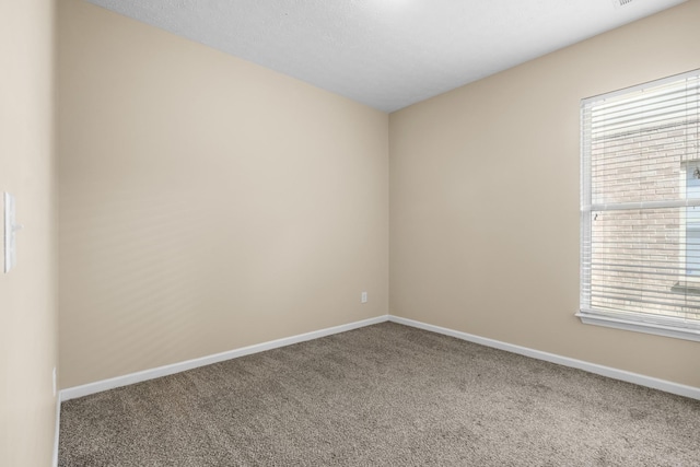 unfurnished room with carpet floors and baseboards