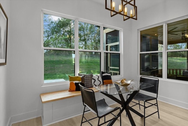 dining room featuring light wood finished floors, an inviting chandelier, and baseboards