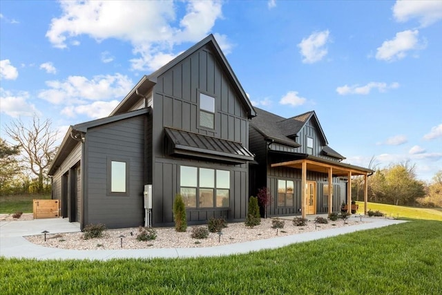 back of property with concrete driveway, board and batten siding, an attached garage, and a lawn