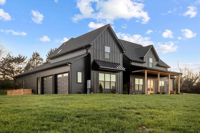 rear view of house featuring board and batten siding, a standing seam roof, a lawn, and metal roof