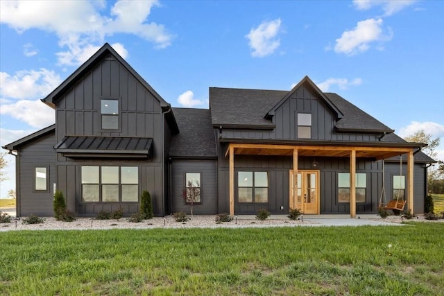 back of property featuring a yard, a shingled roof, and board and batten siding