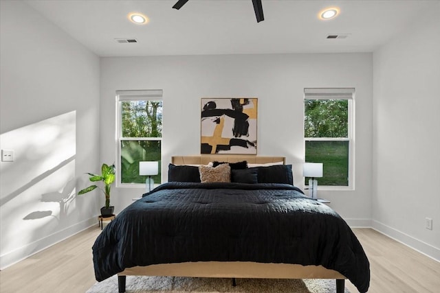 bedroom featuring light wood-style floors, visible vents, and baseboards