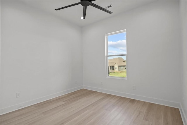 empty room with baseboards, a ceiling fan, and light wood-style floors