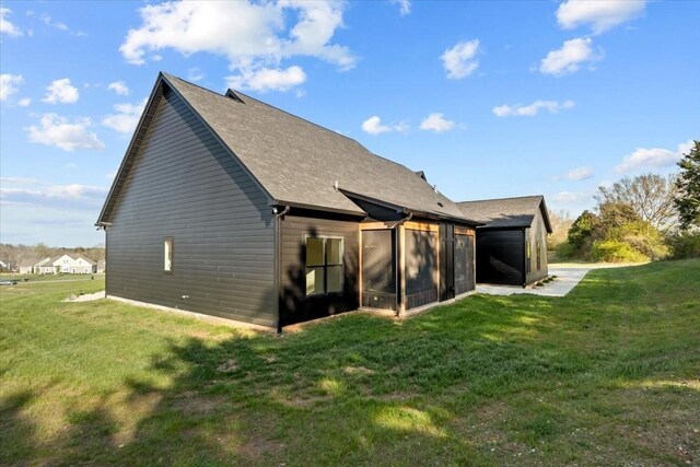 rear view of property featuring a lawn and a sunroom