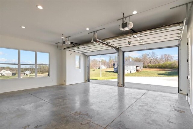 garage with recessed lighting, baseboards, and a garage door opener