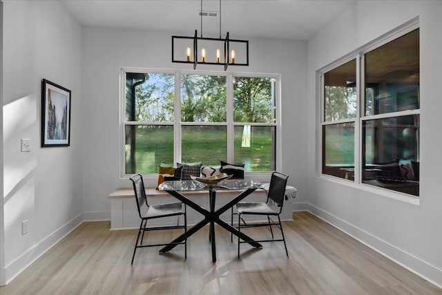 dining space featuring a chandelier, light wood finished floors, breakfast area, and visible vents