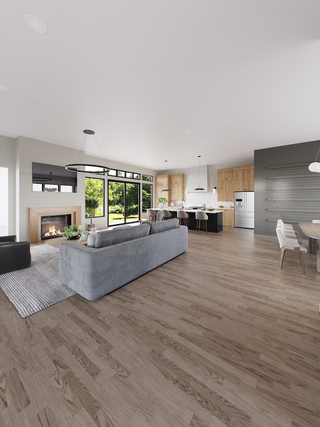 unfurnished living room featuring a glass covered fireplace and wood finished floors