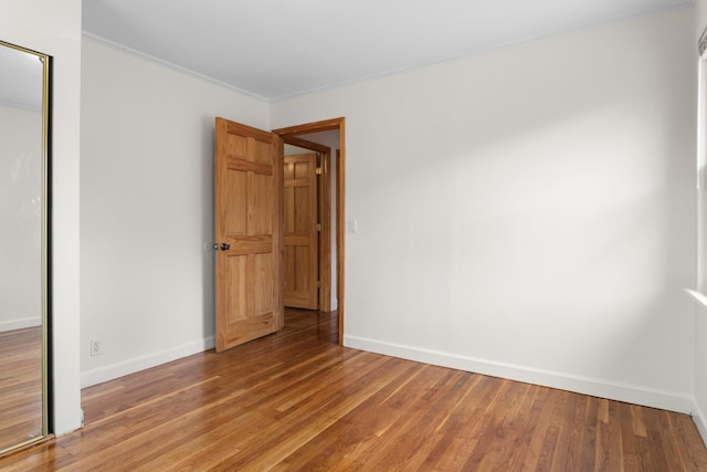 unfurnished bedroom featuring light wood-style flooring, baseboards, and a closet