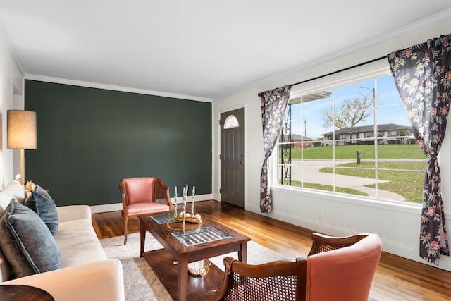 living room featuring crown molding, baseboards, and wood finished floors