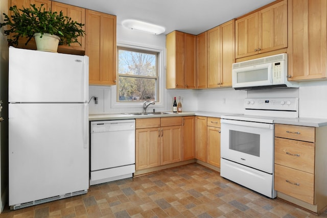 kitchen with light countertops, white appliances, a sink, and light brown cabinetry