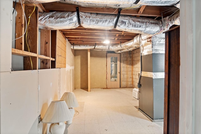 unfinished below grade area featuring heating unit and tile patterned floors