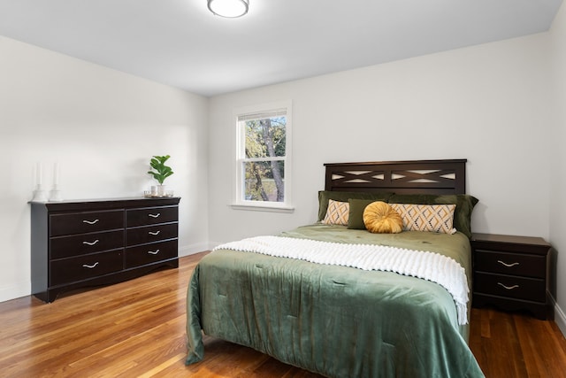 bedroom with baseboards and wood finished floors