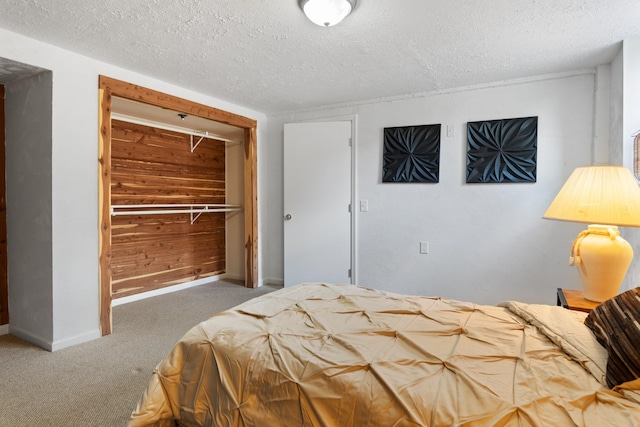 bedroom with carpet, baseboards, and a textured ceiling