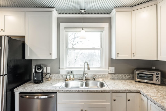 kitchen featuring light countertops, appliances with stainless steel finishes, a sink, and white cabinetry