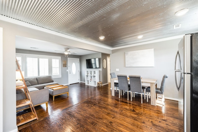 living area featuring a ceiling fan, crown molding, baseboards, and dark wood-style flooring