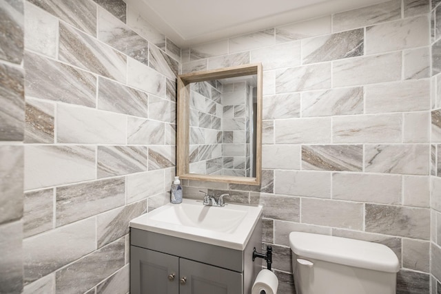 half bathroom with tasteful backsplash, tile walls, vanity, and toilet