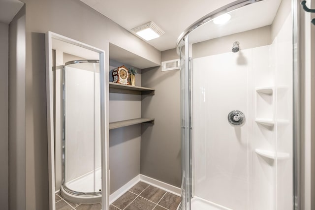 bathroom featuring a stall shower, visible vents, and baseboards