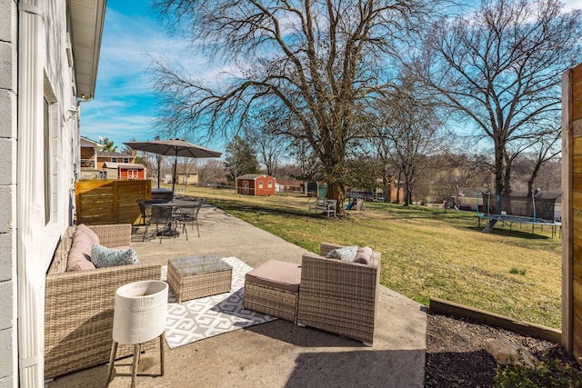 view of patio featuring an outbuilding, outdoor dining area, an outdoor hangout area, a storage unit, and a trampoline