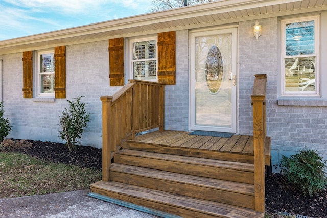 view of exterior entry with crawl space and brick siding