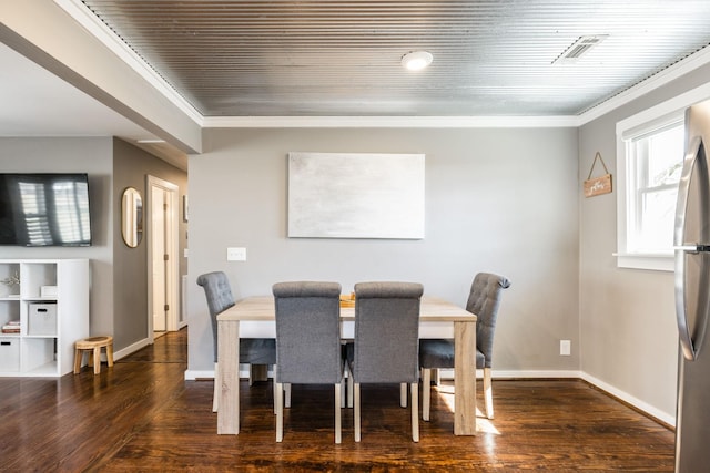 dining space featuring ornamental molding, dark wood finished floors, and baseboards