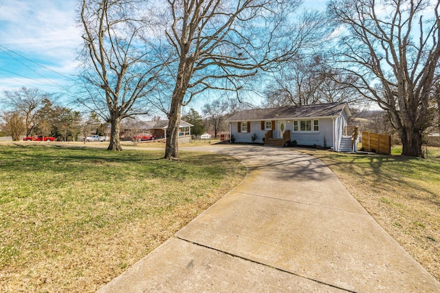 ranch-style house featuring brick siding, driveway, a front lawn, and fence