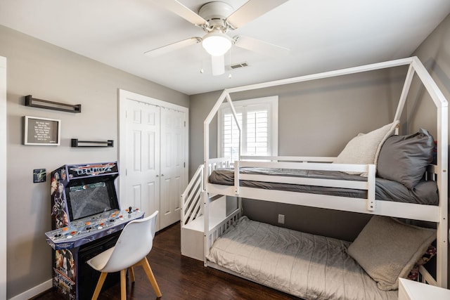 bedroom featuring visible vents, baseboards, a ceiling fan, dark wood-style floors, and a closet